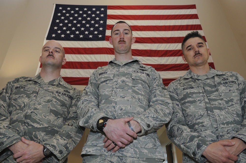 three airmen pose with their march mustaches on display