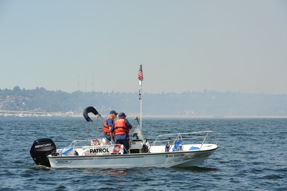 Two Coast Guard Auxiliary members stand on boat