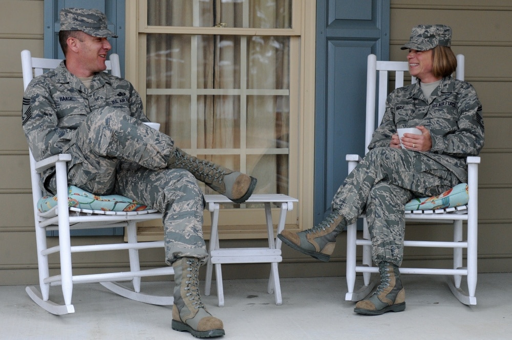 air force couple sits on porch drinking coffee