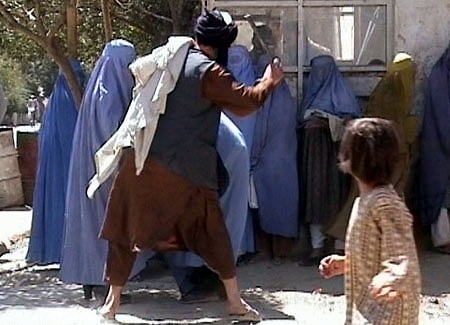 Taliban religious police beating an Afghan woman for removing her burka in public, in August of 2001, shortly before the Taliban was removed from power (<a href="http://www.rawa.org/index.php" target="_blank" rel="noreferrer noopener">Revolutionary Association of the Women of Afghanistan</a>/ Wikimedia Commons)