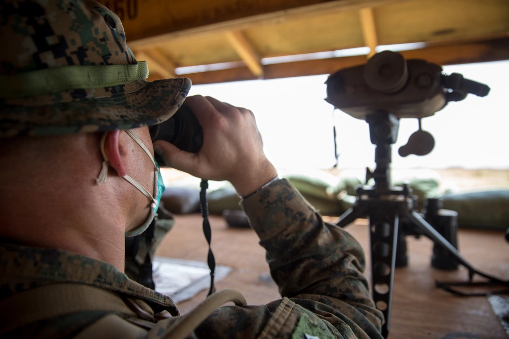 Marine at Baledogle Military Airfield uses a rangefinder to assist with the creation of range cards