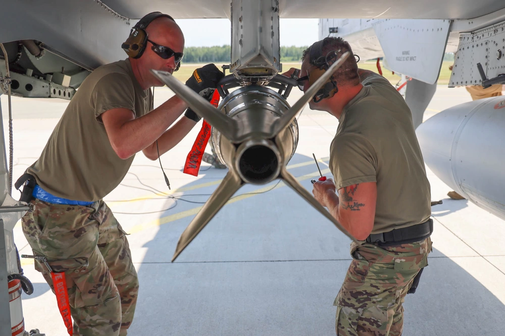 Air Defender 2023 aircraft maintainers attach a bomb on an A-10