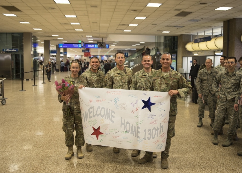 Airmen holding welcome home sign