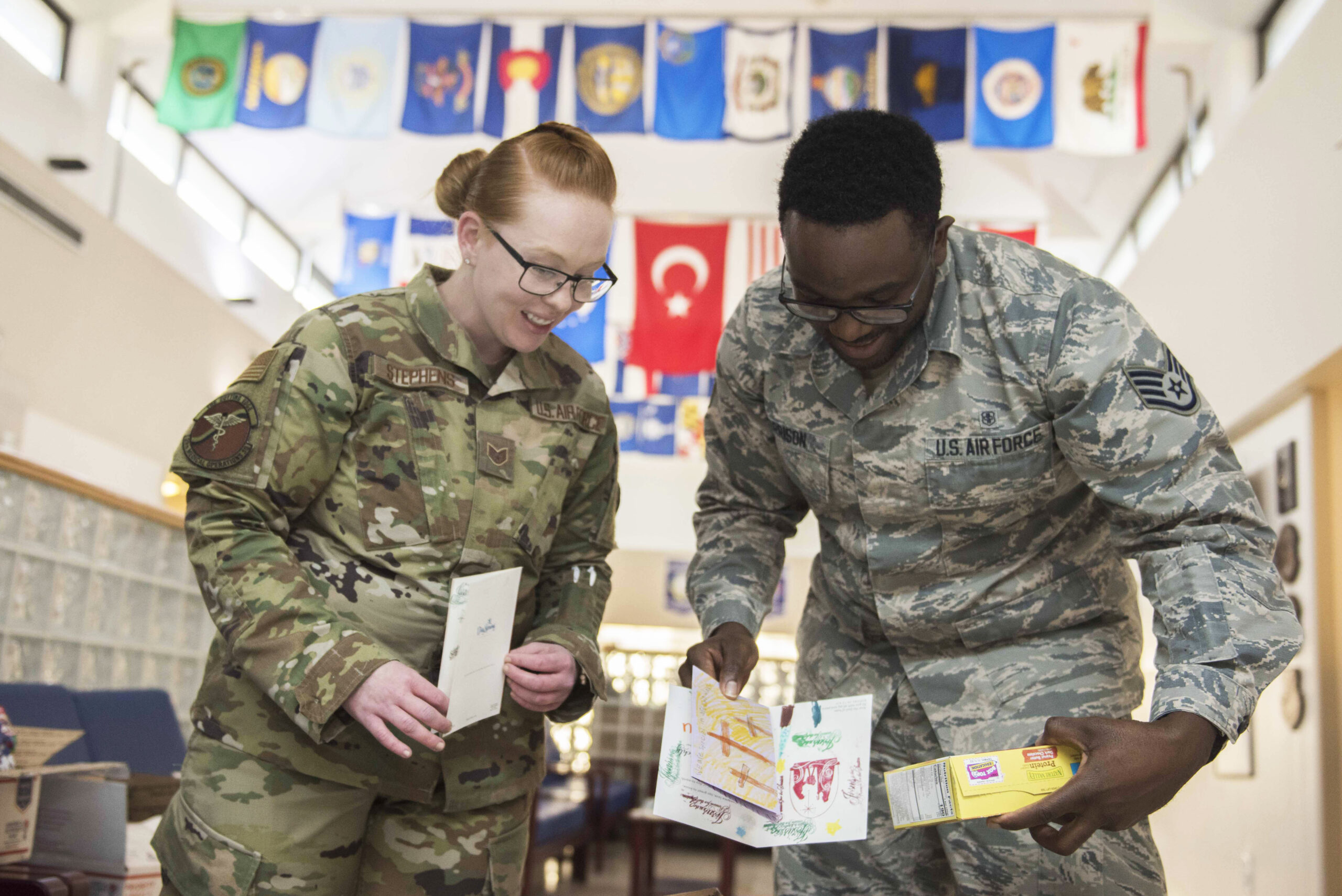 U.S. Air Force Staff Sgt. Kaci Stephens, 39th Medical Operations Squadron military treatment facility personnel reliability assurance program monitor (left), and U.S. Air Force Staff Sgt. Christopher Morrison, 39th MDOS flight and operational medical technician read holiday cards and letters Dec. 11, 2019, at Incirlik Air Base, Turkey. The cards and letters came with a delivery of care packages sent by church volunteers from Murrysville, Pennsylvania. 