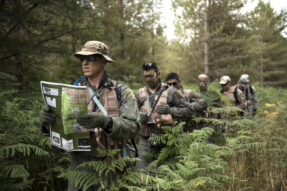 Aircrew from the 48th Operations Group conduct land navigation during Combat Survival Training in camouflage colors