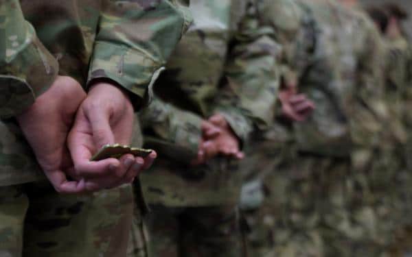 Army coin in soldiers' hands