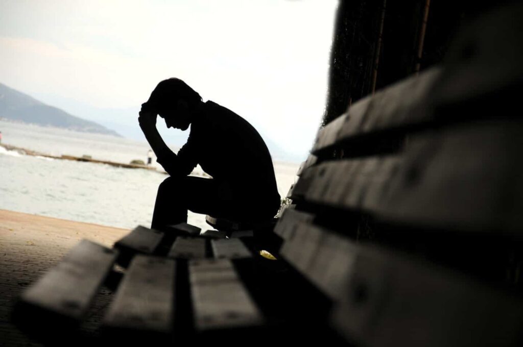 man seated on bench dealing with post traumatic stress disorder