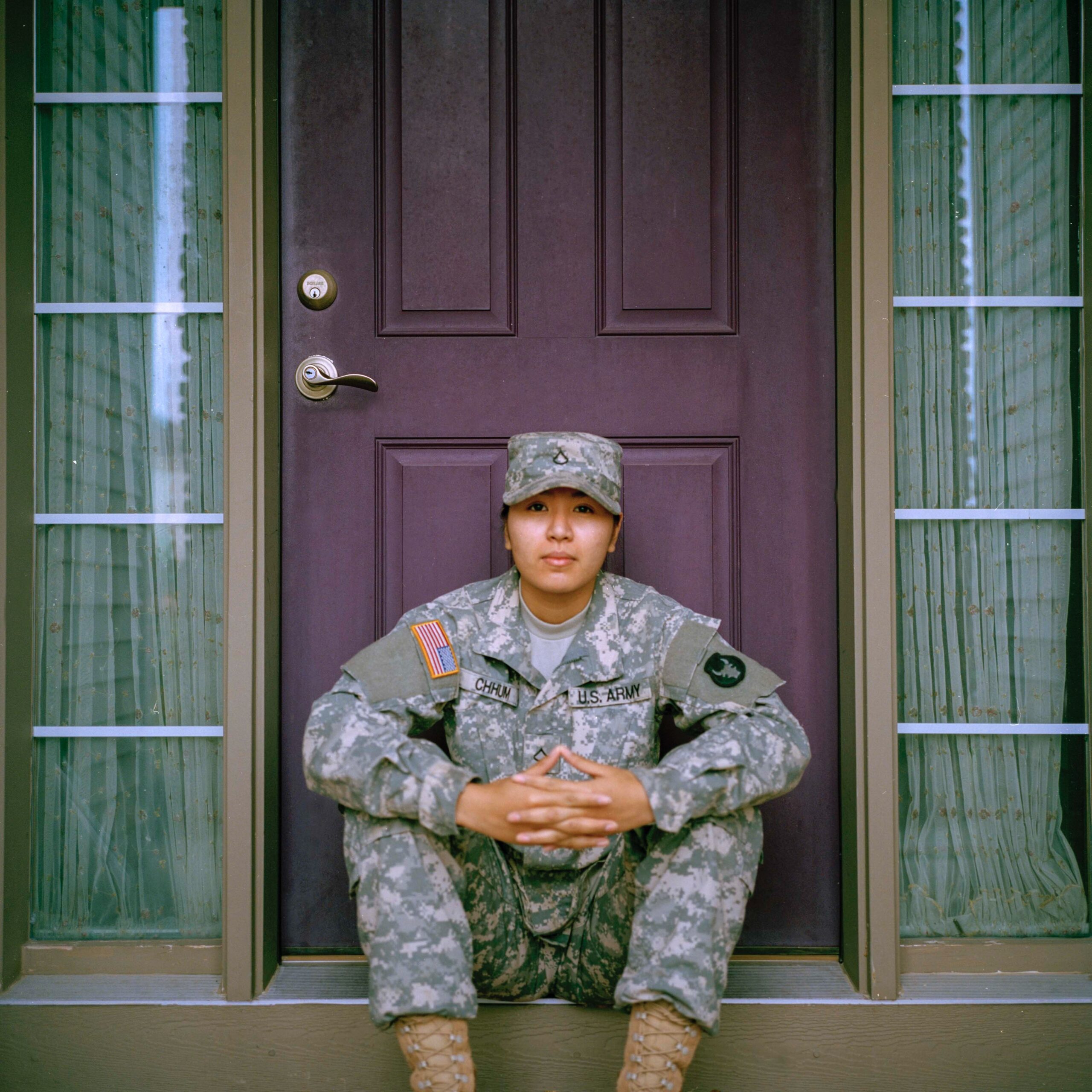 female soldier sits in front of door