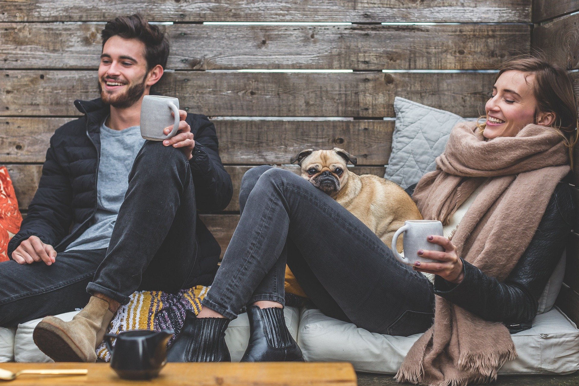 young couple smiling together while drinking coffee