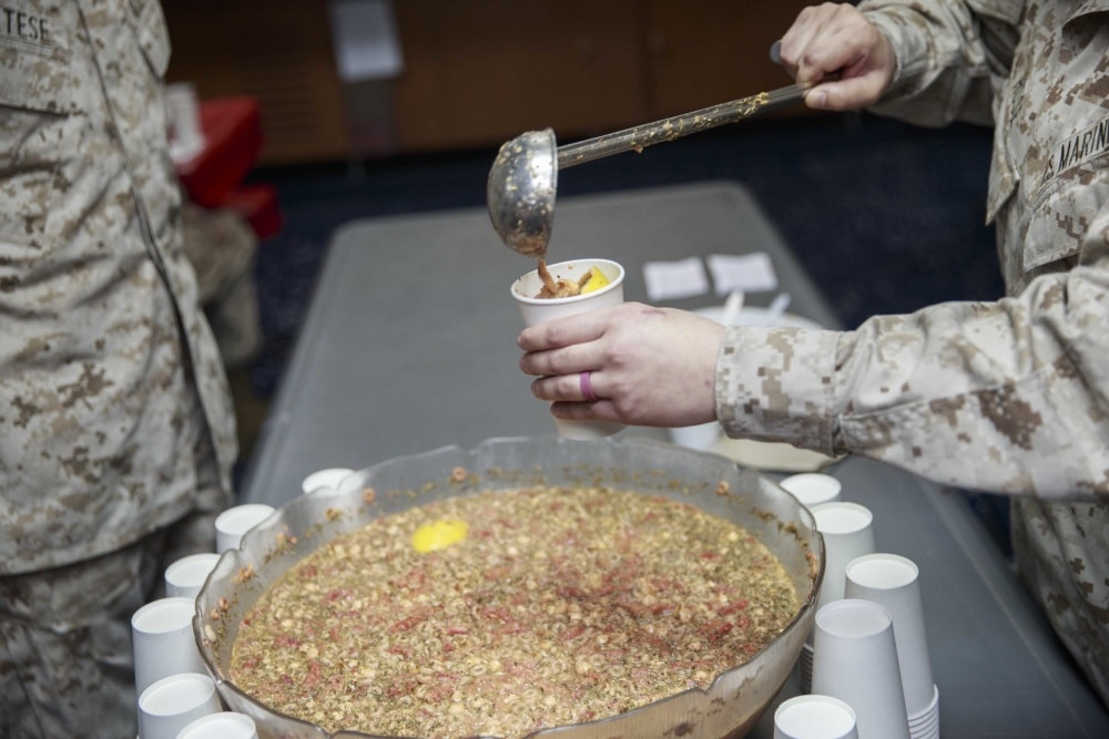 marine pours grog into cup for annual military tradition