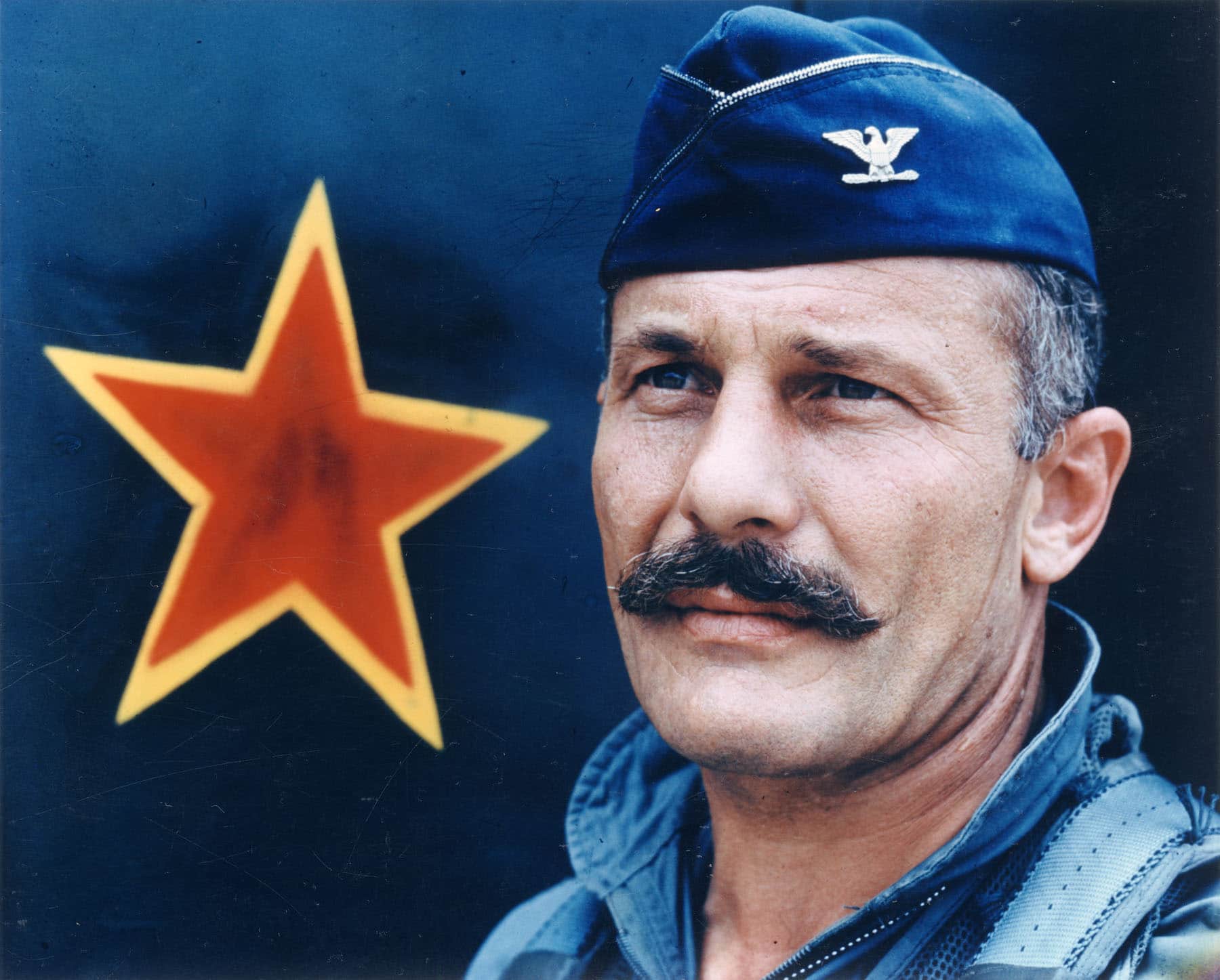 triple ace robin olds in front of an aircraft