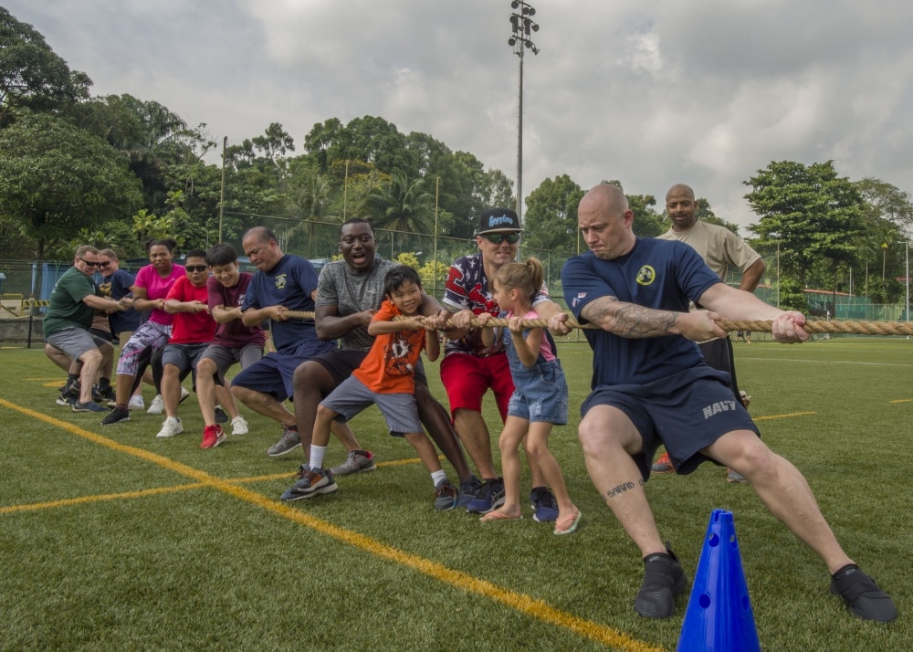 adults playing tug o war on base