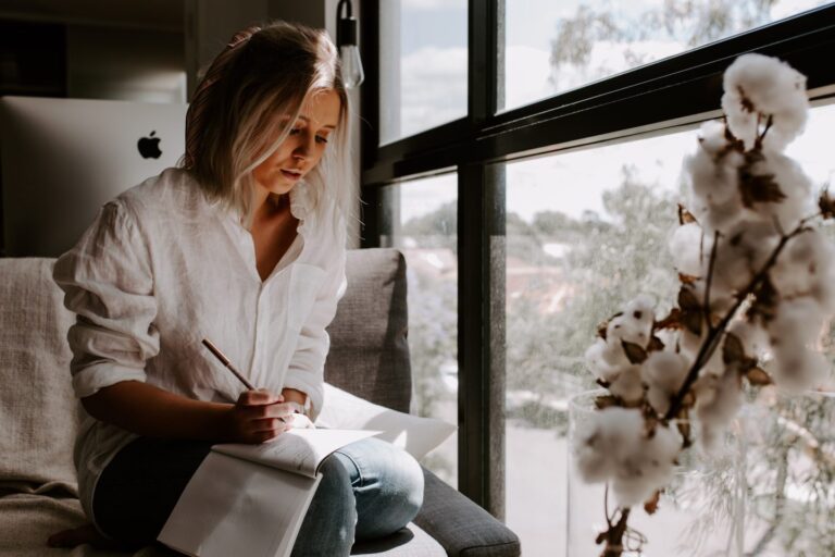 woman writing letter by a window