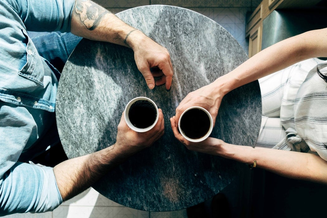 couple sitting across from one another drinking coffee