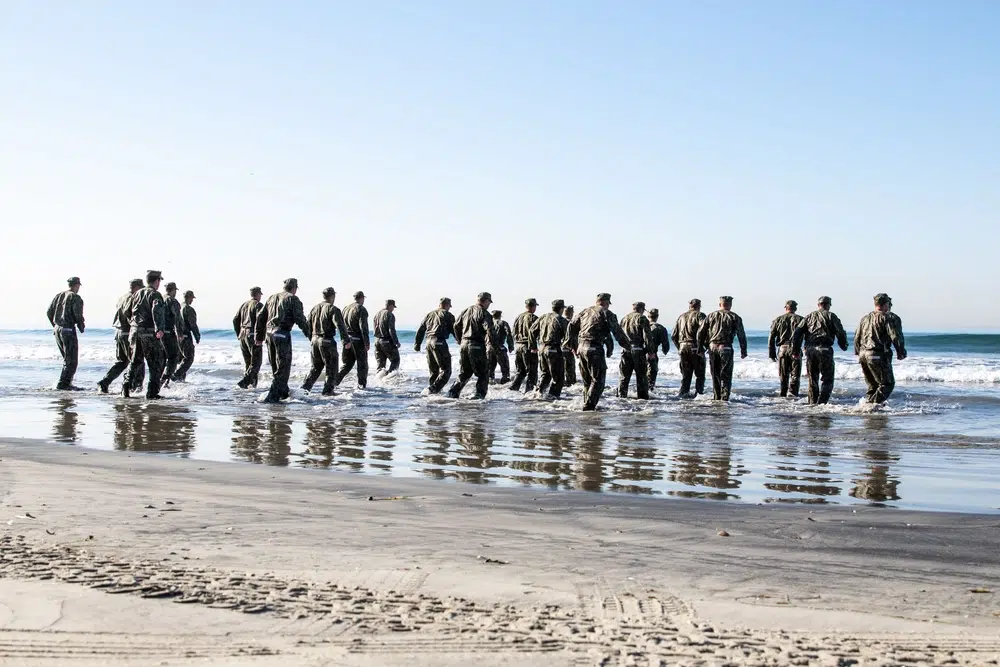 SEAL candidates run into the surf