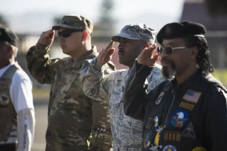 service members salute while national anthem plays