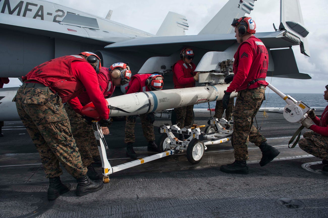 Marines assigned to the Thunderbolts of Marine Fighter Attack Squadron (VMFA) 251 remove a training AGM-88 High Speed Anti-Radiation Missile (HARM) from an F/A-18C Hornet on the flight deck of the Nimitz-class aircraft carrier USS Theodore Roosevelt (CVN 71).